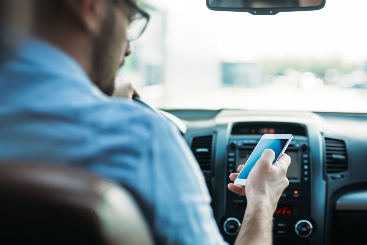 Distracted driving - man using phone while driving