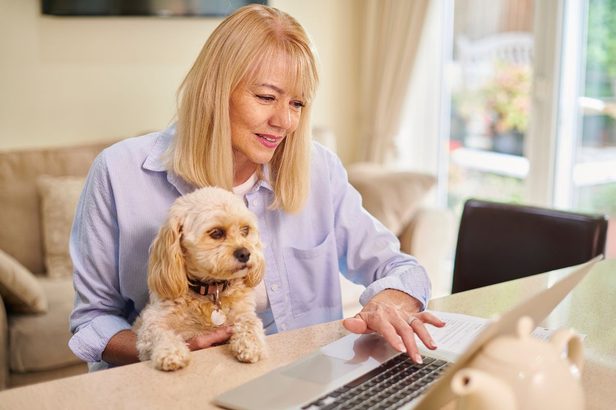 Pet Insurance - Woman with dog, using computer