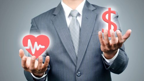 Health insurance - Person holding heart health and dollar sign