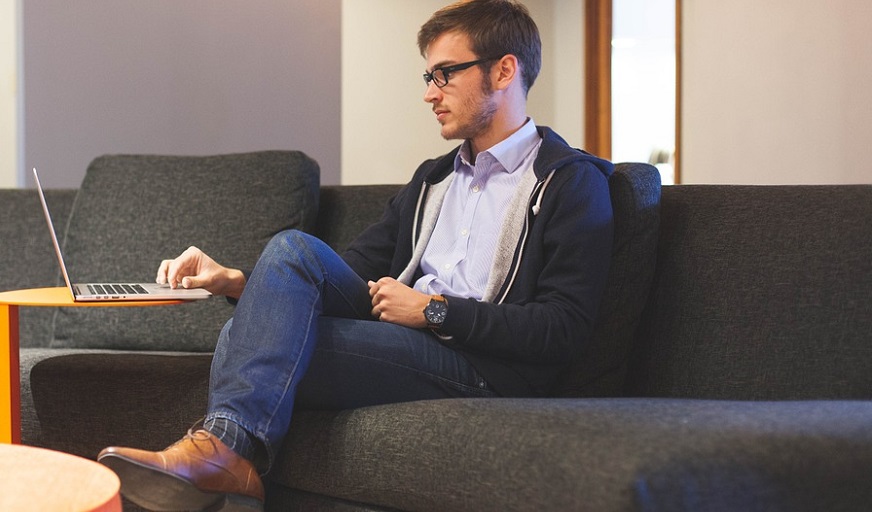 Self Employed Liability Insurance - Man sitting on couch using laptop