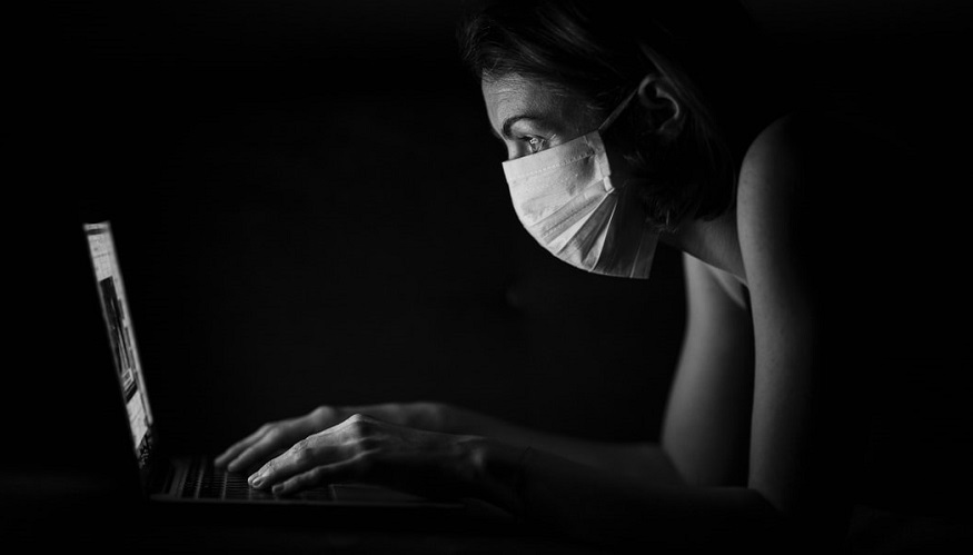 US life insurance - person wearing mask using computer