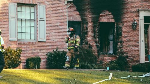 Wildfire preparedness - firefighter and scorched home