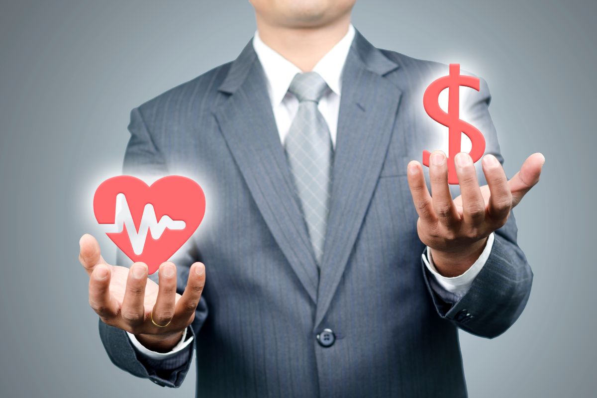 Health insurance - Person holding heart health and dollar sign