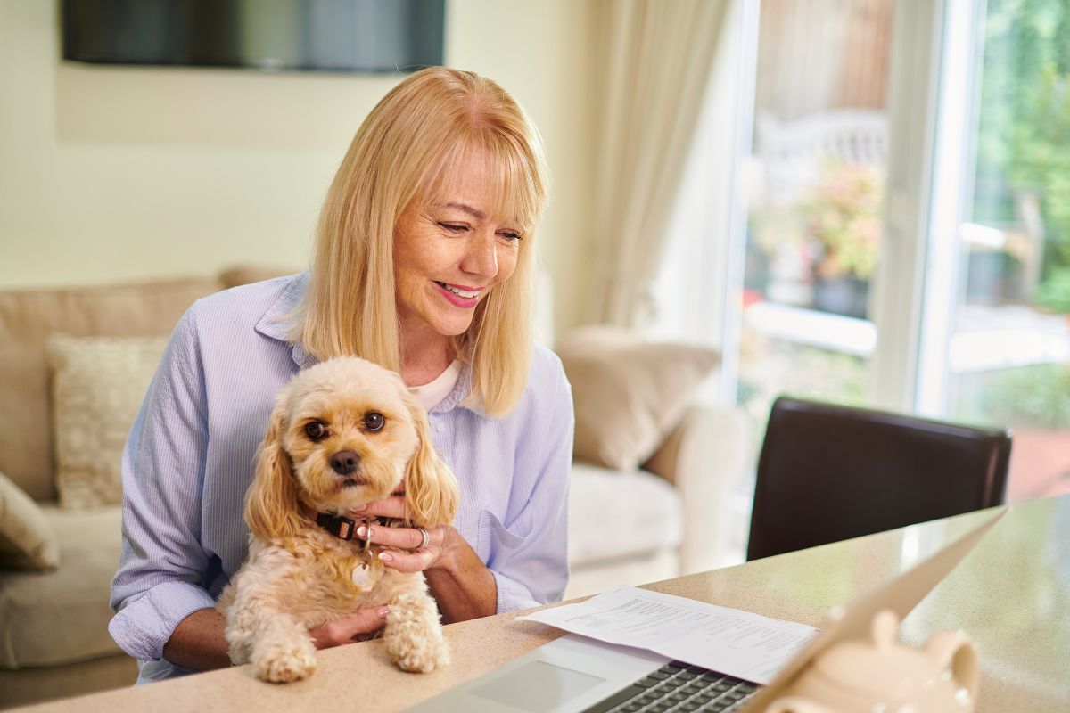 Pet insurance - woman on computer with dog
